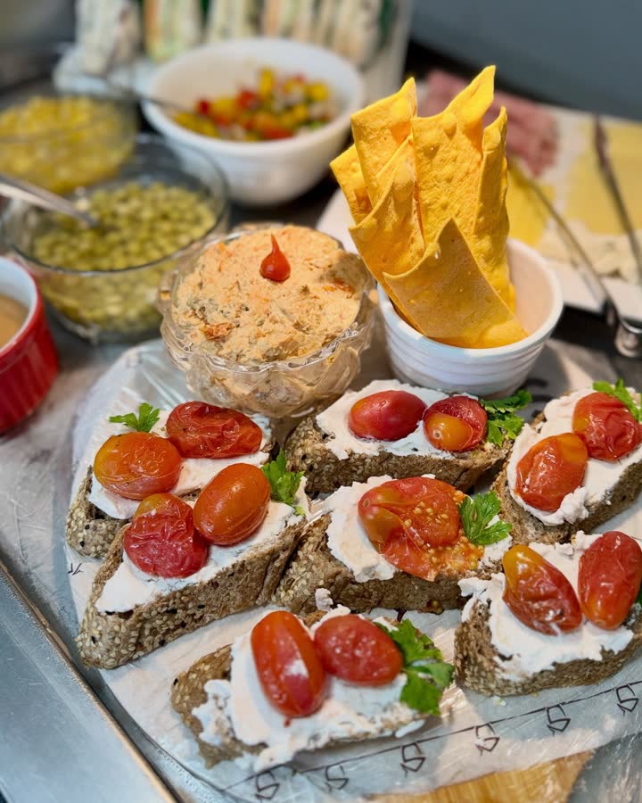 Travessa do buffet da Padoca com canapés de tomate cereja, pastas e cones de queijo.